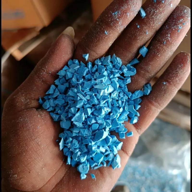 Hand holding blue PVC pipe regrind