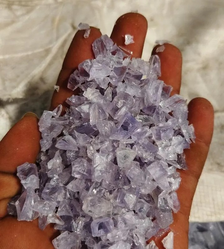 Hand holding clear natural PVC regrind