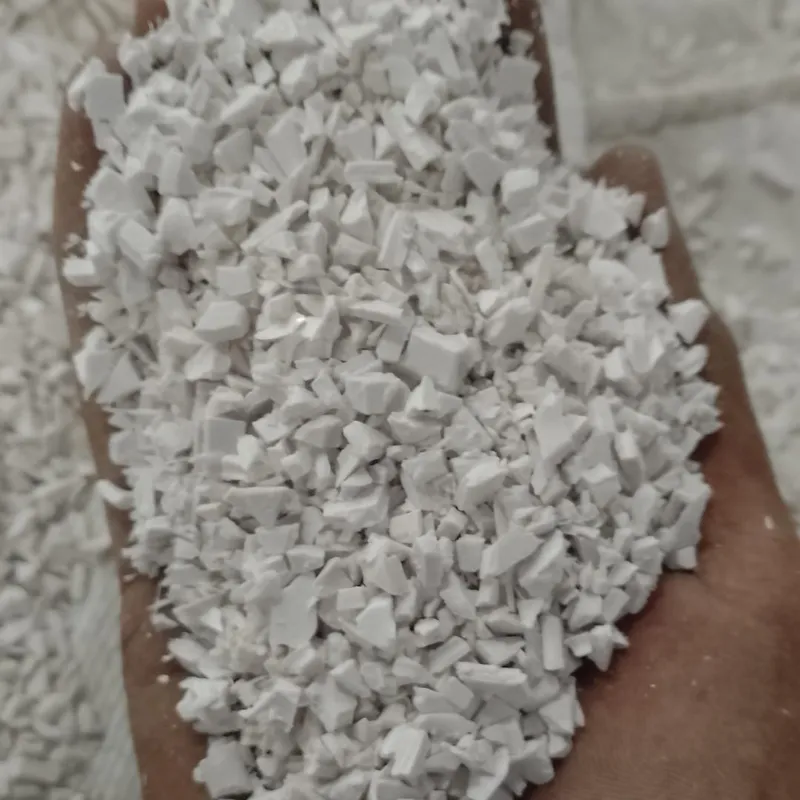 Hand holding white PVC sheet regrind