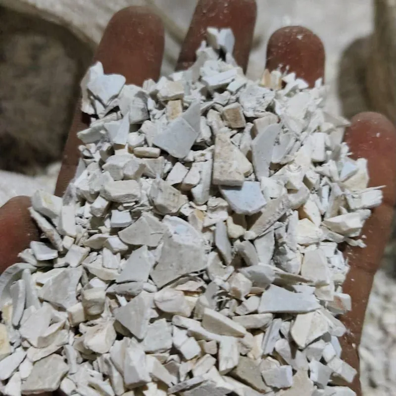 Handful of white and light grey PVC pipe regrind