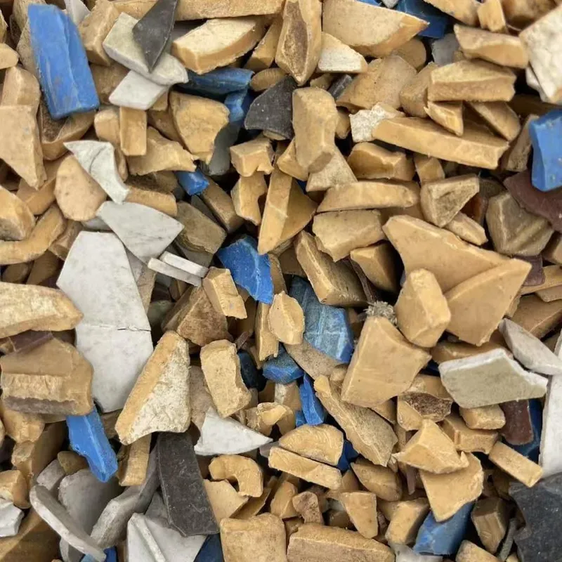 Mixed-colour PVC regrind with beige, white and blue pieces, close-up