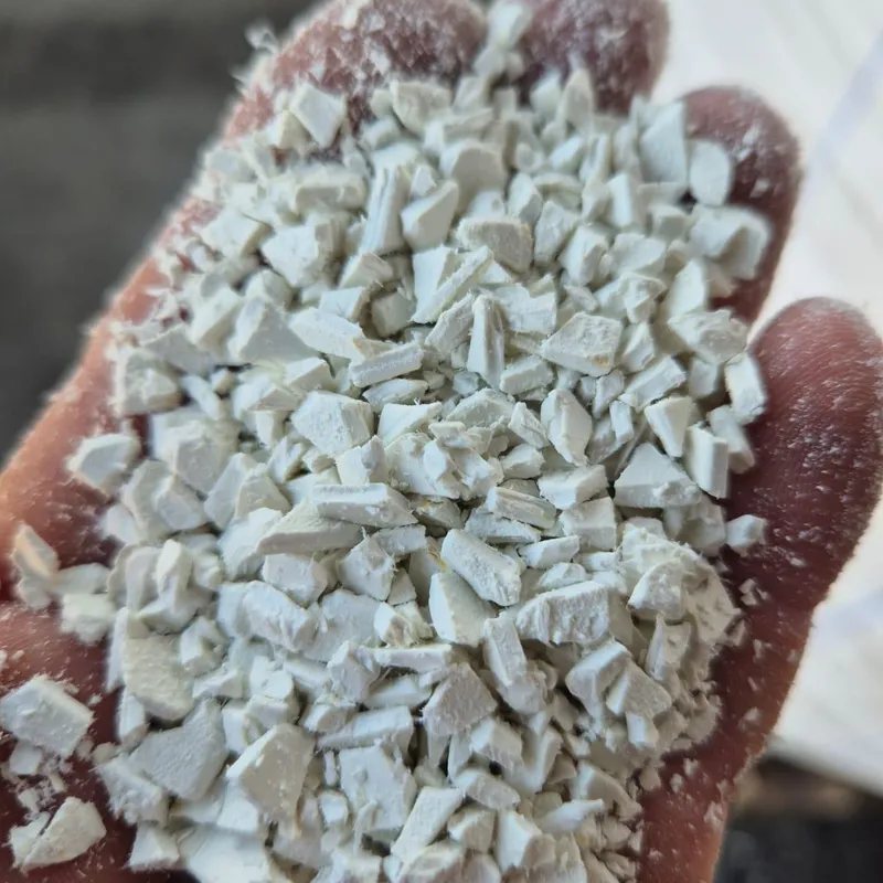 Hand holding white PVC sheet regrind