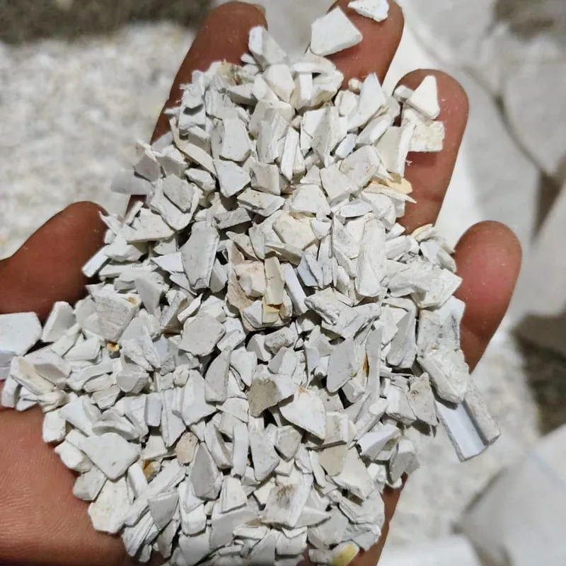 White PVC pipe regrind in an open hand, close-up