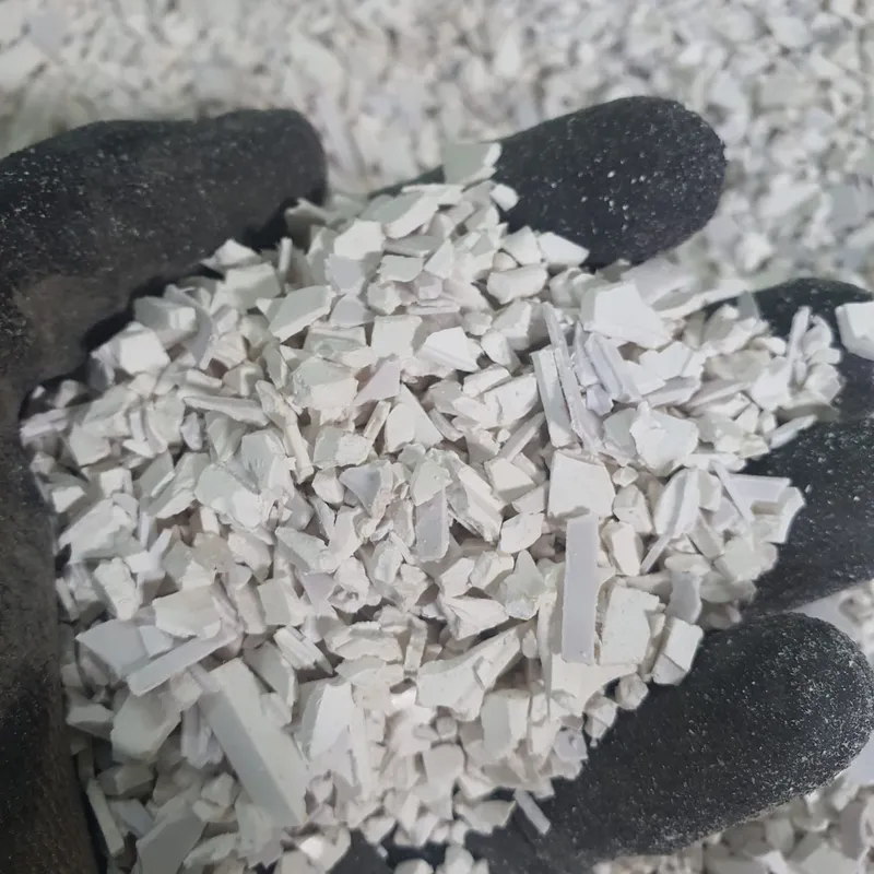 Gloved hand holding white PVC window profile regrind