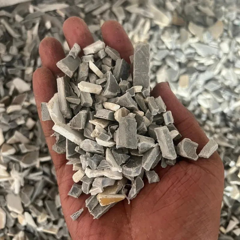 Grey and white PVC pipe regrind in an open hand