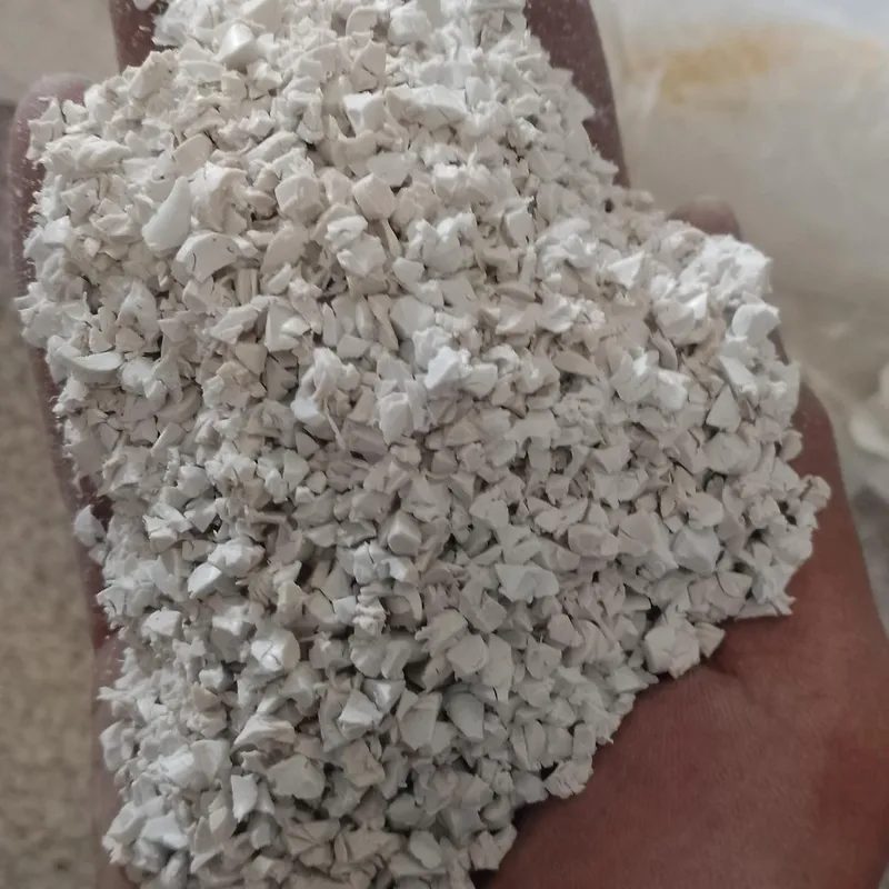 Handful of white PVC sheet regrind, close-up